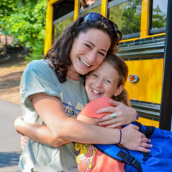 Solo traveler hugging a camper.