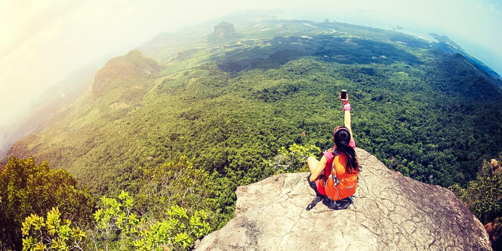 Solo traveler taking a selfie on top of a mountain.